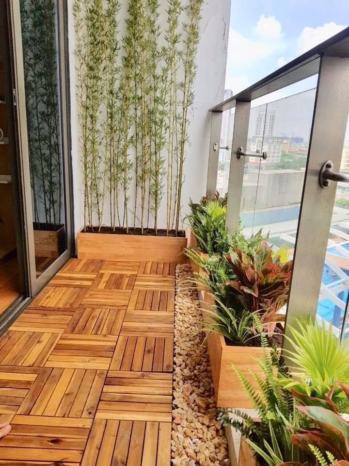 Ban công chung cư nhỏ với sàn gỗ và mảng cây xanh