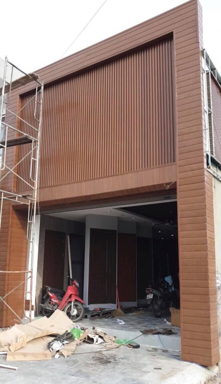 Hai trụ mặt tiền ốp thanh ngang màu gỗ trong quá trình hoàn thiện